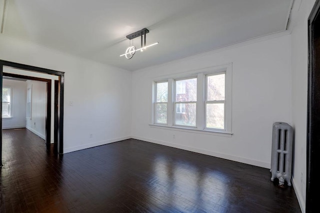 spare room with a healthy amount of sunlight, dark wood-type flooring, and radiator