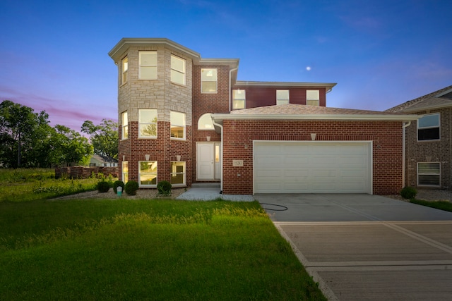 view of front of property with a garage and a yard