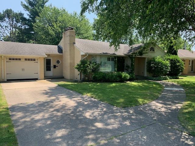 ranch-style house with a garage and a front lawn