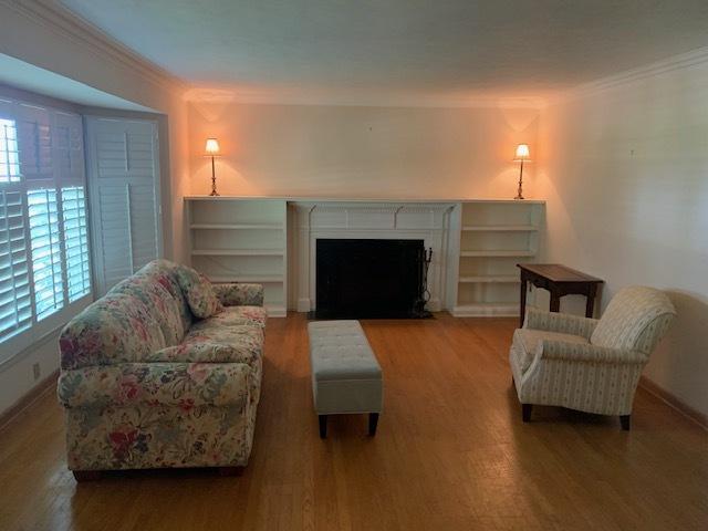 living room with crown molding and hardwood / wood-style flooring