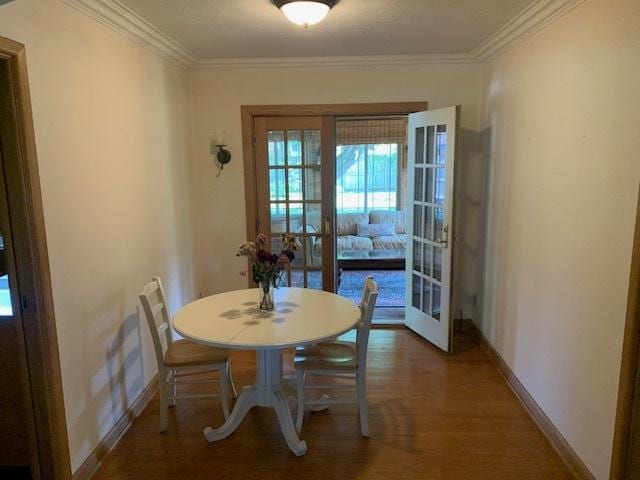 dining area featuring crown molding, dark wood-type flooring, and french doors