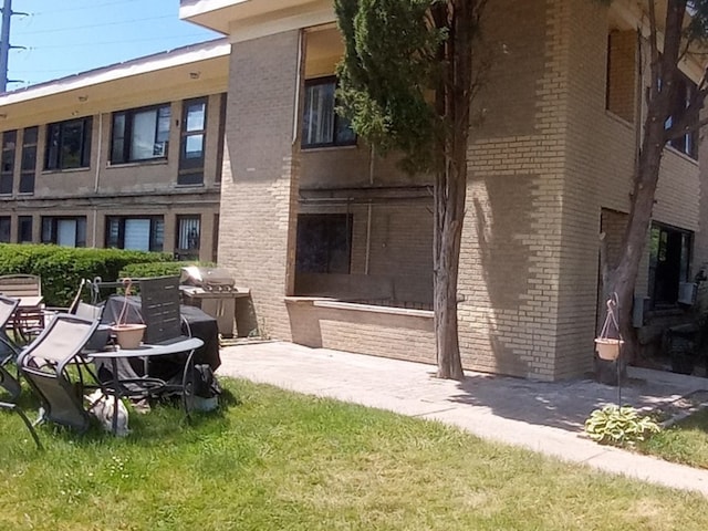 back of house featuring a lawn and a patio area