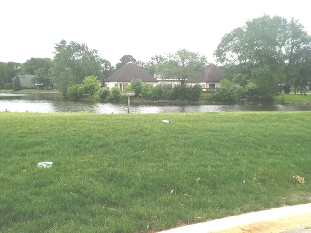 view of community featuring a yard and a water view