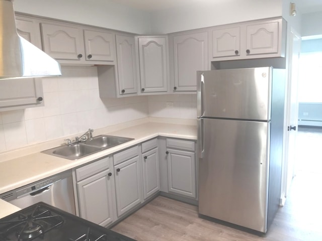 kitchen with tasteful backsplash, sink, light wood-type flooring, gray cabinetry, and stainless steel appliances