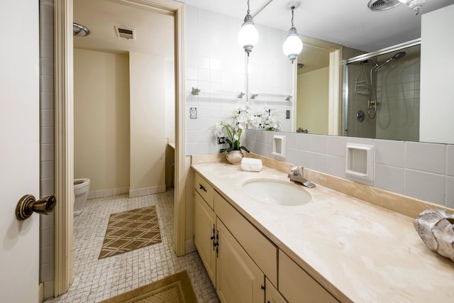 bathroom featuring tasteful backsplash, vanity, toilet, and a shower with shower door