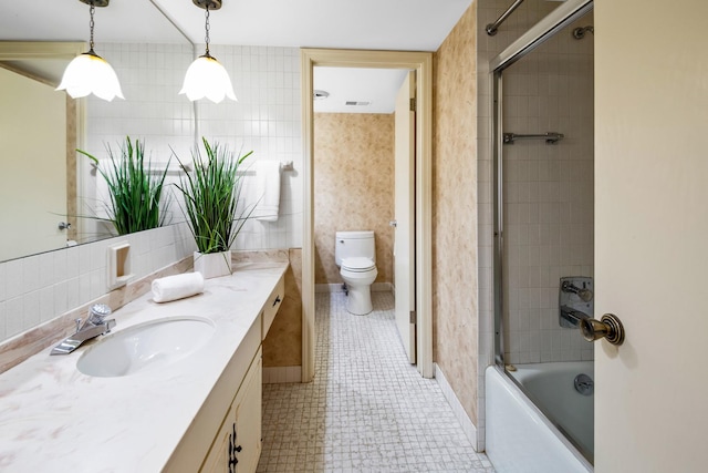 full bathroom featuring combined bath / shower with glass door, vanity, and toilet