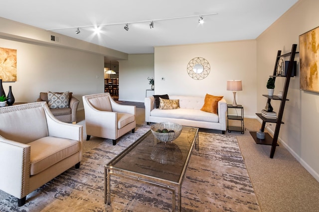 carpeted living room featuring rail lighting