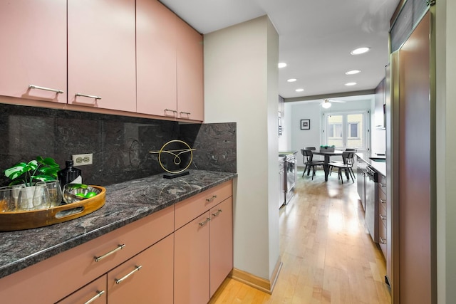 kitchen with tasteful backsplash, ceiling fan, dishwasher, light hardwood / wood-style floors, and dark stone counters