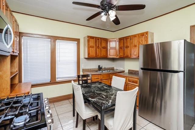 kitchen featuring range with two ovens, ceiling fan, sink, stainless steel fridge, and light tile patterned floors