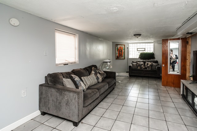 living room with light tile patterned flooring, a textured ceiling, and a healthy amount of sunlight