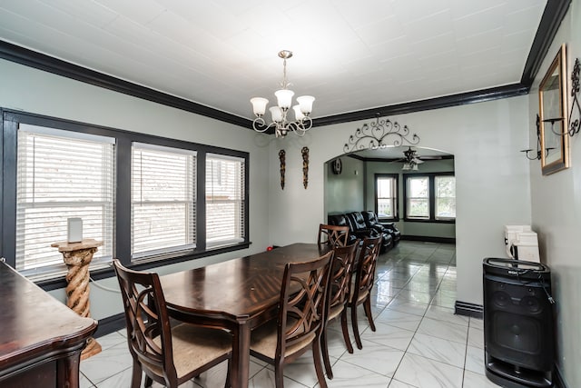 dining room with ornamental molding, ceiling fan with notable chandelier, and light tile patterned floors