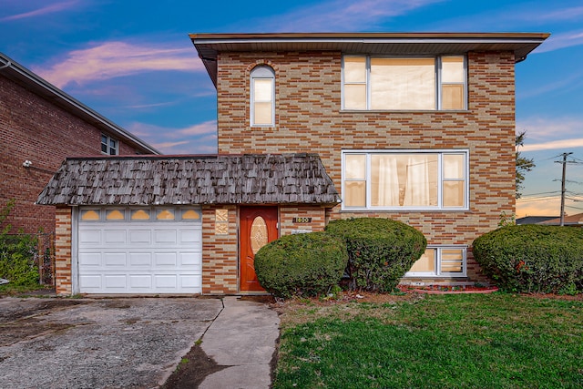 front facade with a yard and a garage