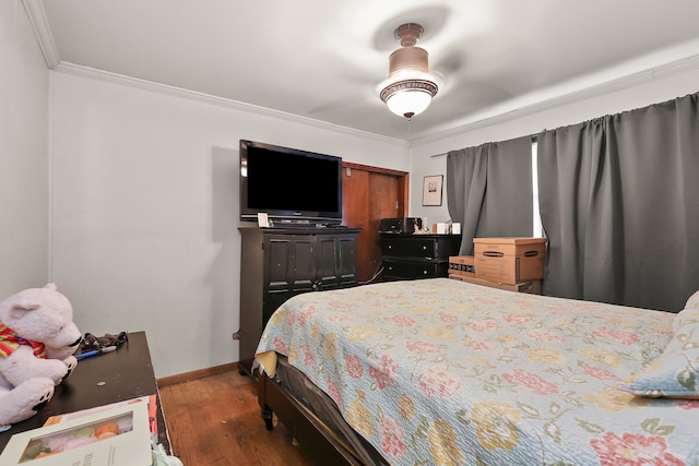 bedroom featuring crown molding, hardwood / wood-style flooring, and ceiling fan