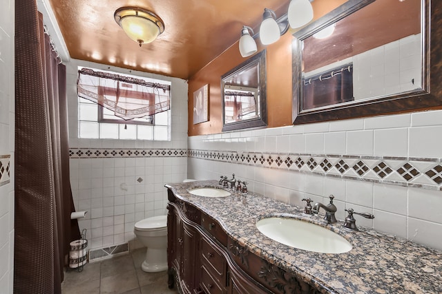 bathroom featuring toilet, vanity, tile walls, and tile patterned flooring