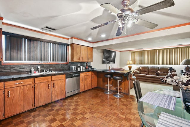 kitchen with sink, backsplash, dark parquet flooring, ceiling fan, and stainless steel dishwasher