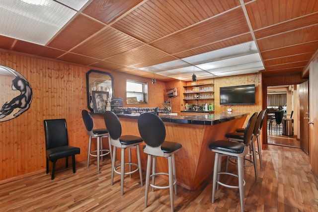 bar featuring hardwood / wood-style floors, wooden walls, and wooden ceiling