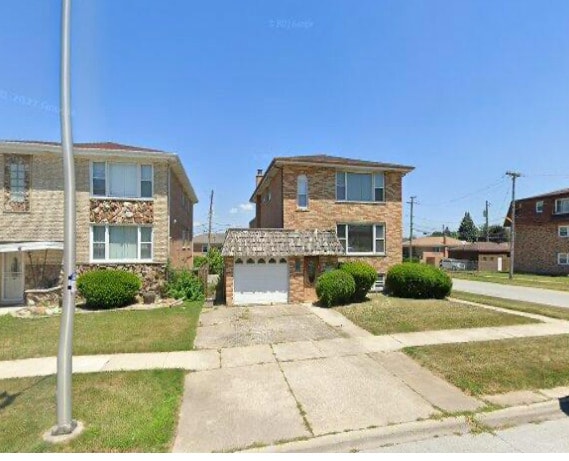 view of front facade with a front yard and a garage