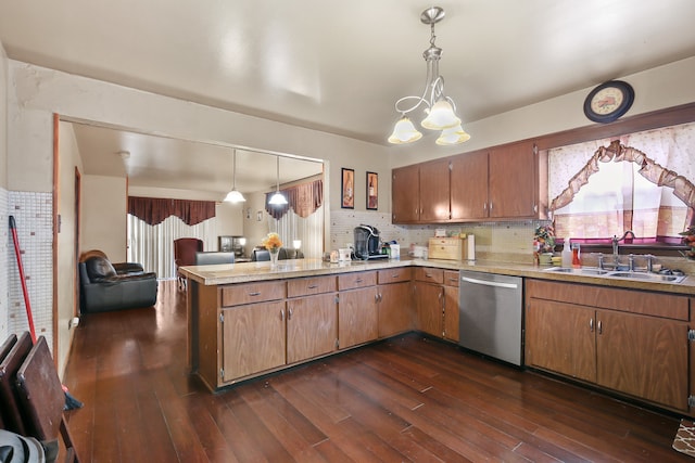 kitchen with kitchen peninsula, hanging light fixtures, dark hardwood / wood-style flooring, dishwasher, and sink