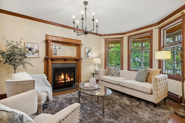 living room featuring wood-type flooring, a baseboard heating unit, crown molding, and a chandelier