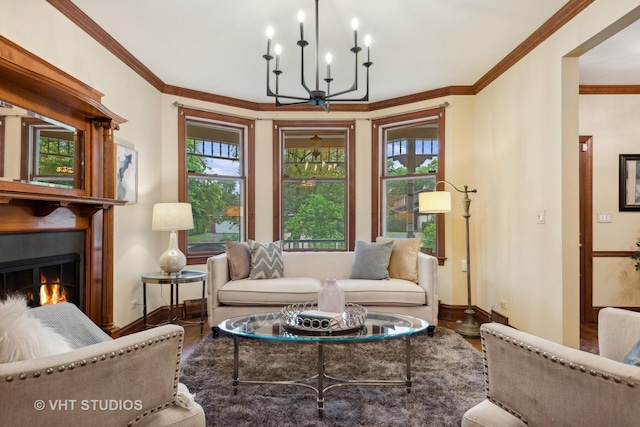 living area featuring wood finished floors, a lit fireplace, an inviting chandelier, crown molding, and baseboards