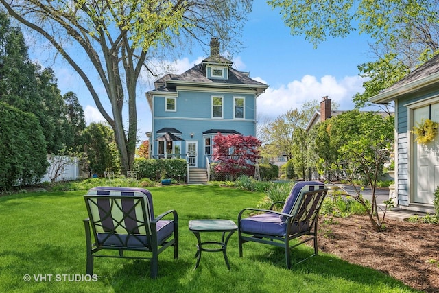 rear view of property with a yard and a chimney