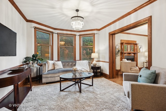 living room with an inviting chandelier, crown molding, and light hardwood / wood-style floors