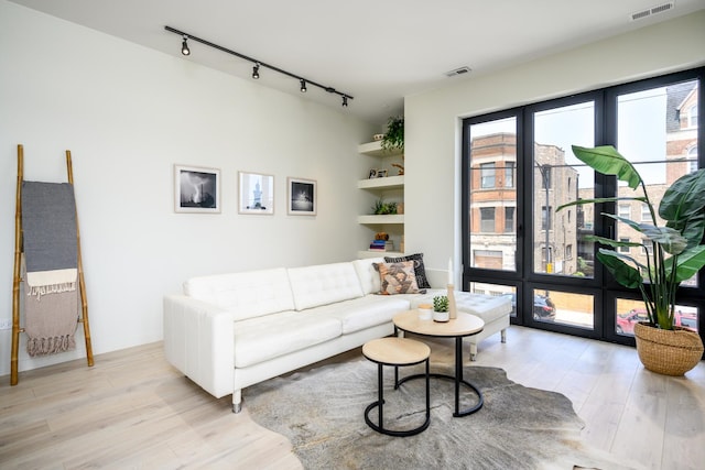 living room featuring track lighting and light hardwood / wood-style floors