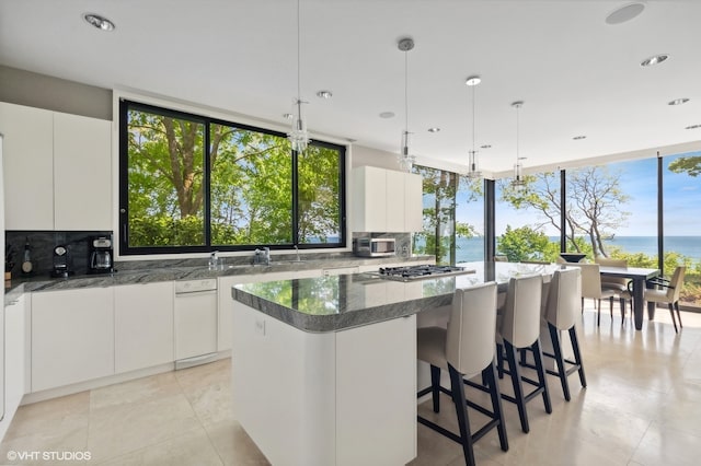 kitchen with a water view, white cabinetry, and a center island