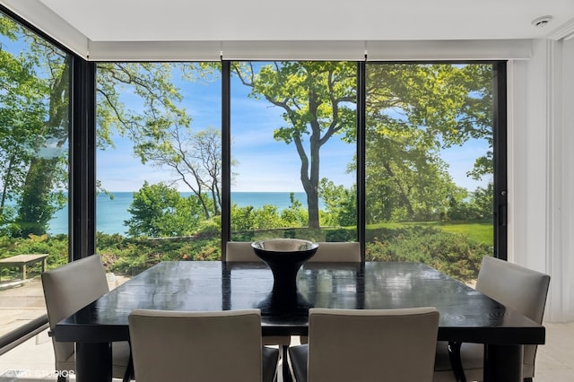 sunroom featuring a water view