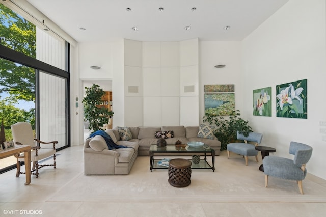 living room featuring a towering ceiling and light tile patterned floors