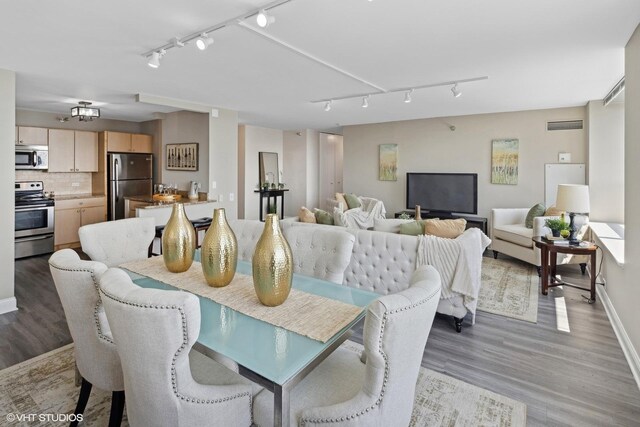 dining room featuring hardwood / wood-style floors and rail lighting