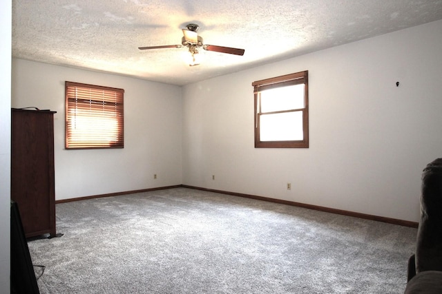 unfurnished room featuring carpet, ceiling fan, and a textured ceiling