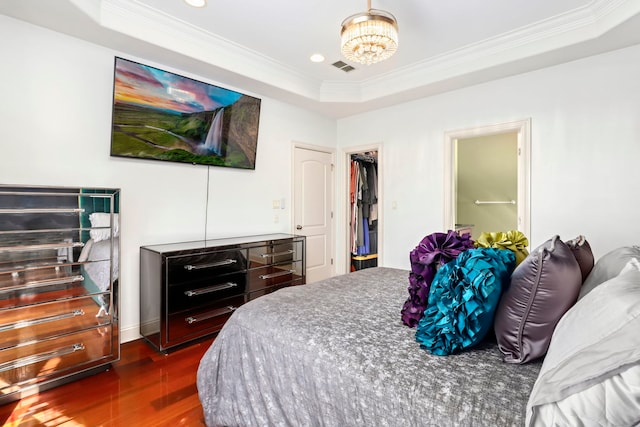 bedroom featuring crown molding, dark hardwood / wood-style floors, a closet, and a tray ceiling