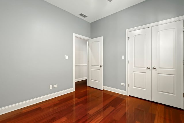 unfurnished bedroom with hardwood / wood-style flooring and a closet