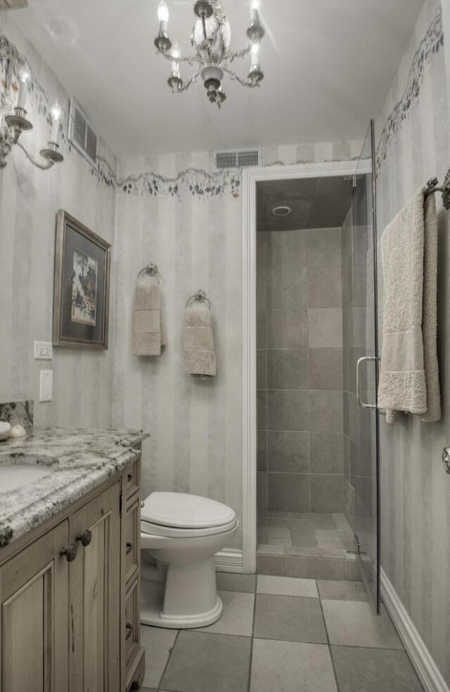 bathroom featuring tile patterned flooring, a notable chandelier, walk in shower, vanity, and toilet