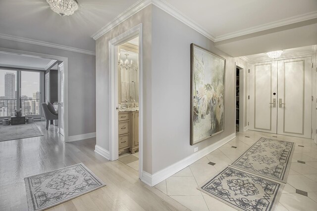 hallway featuring ornamental molding, a chandelier, and light hardwood / wood-style flooring