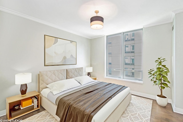 bedroom with hardwood / wood-style floors and ornamental molding