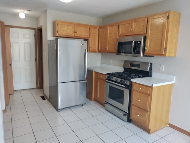 kitchen with light tile patterned floors and stainless steel appliances