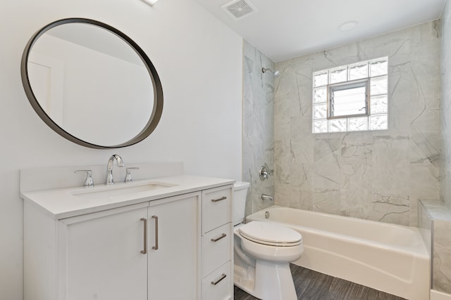 full bathroom with toilet, tiled shower / bath combo, hardwood / wood-style flooring, and vanity