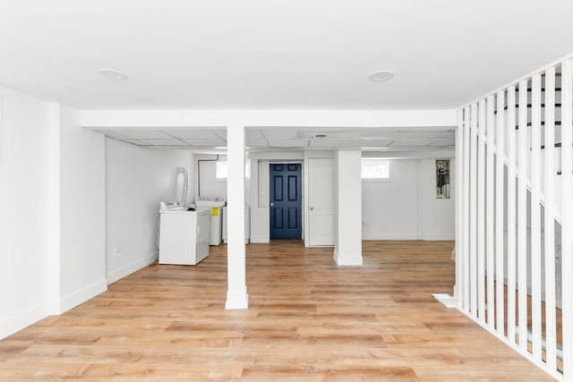 basement with washer and clothes dryer and light hardwood / wood-style flooring