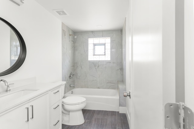 full bathroom with tiled shower / bath combo, vanity, and toilet