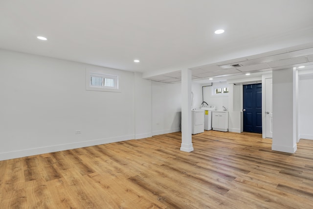 basement with washer and clothes dryer, light wood-type flooring, and plenty of natural light