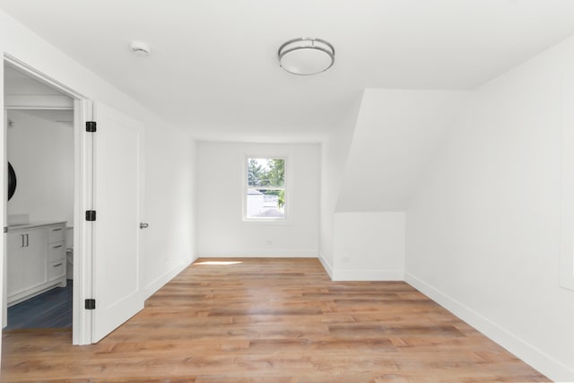 additional living space with light hardwood / wood-style flooring