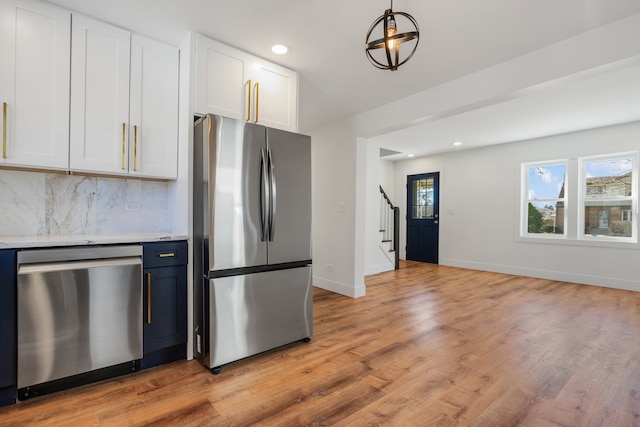 kitchen featuring decorative light fixtures, white cabinetry, appliances with stainless steel finishes, and decorative backsplash