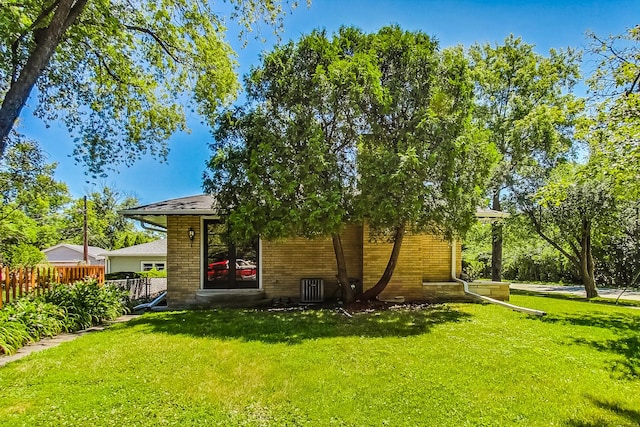 back of property with a lawn and central air condition unit