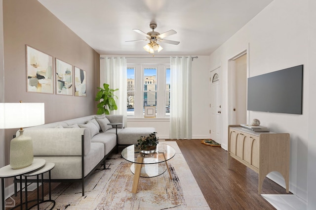 living room featuring ceiling fan and dark hardwood / wood-style flooring