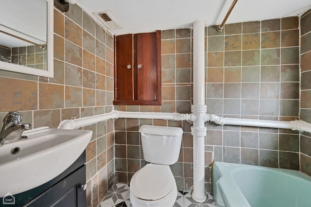 bathroom with tile walls, toilet, and vanity