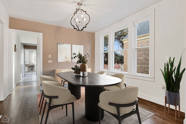 dining area featuring dark hardwood / wood-style floors and an inviting chandelier