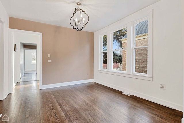 unfurnished dining area featuring dark hardwood / wood-style floors and an inviting chandelier