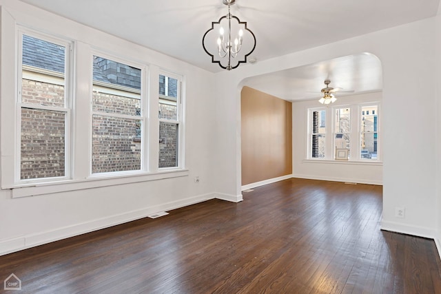 unfurnished dining area with dark wood-type flooring and ceiling fan with notable chandelier